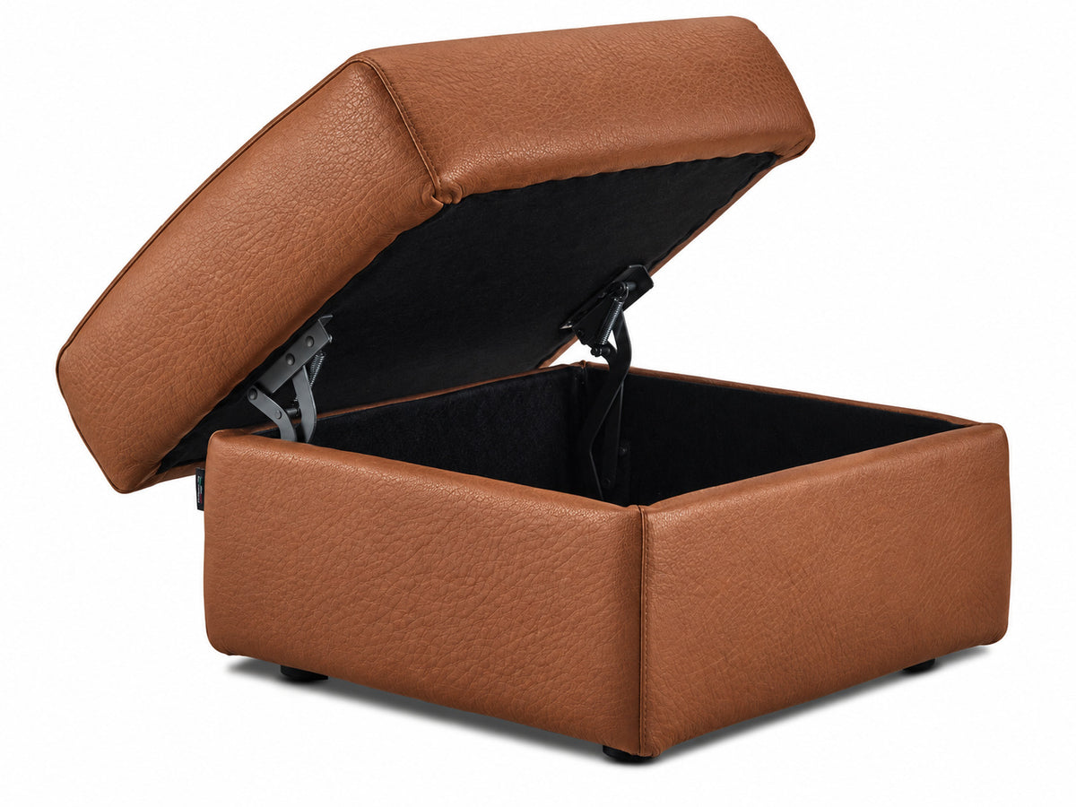 Cognac leather ottoman with hinged cushion raised to reveal the black interior storage compartment