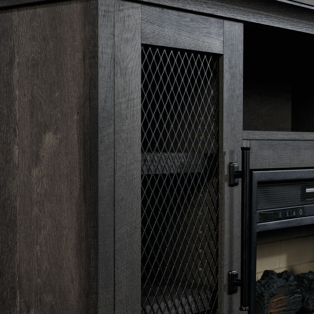 Close-up of Millbrook Fireplace TV Stand showing Fawn Aged Oak finish, black diamond mesh cabinet door and metal handle