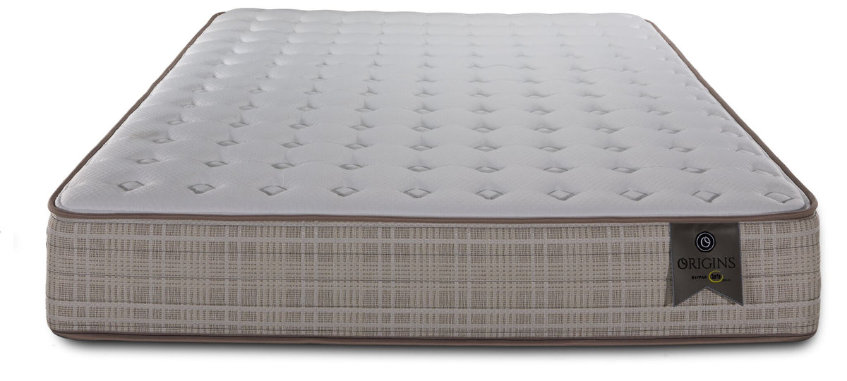 Front view of the Twin mattress highlighting the tufted white surface, brown piping and Origins label