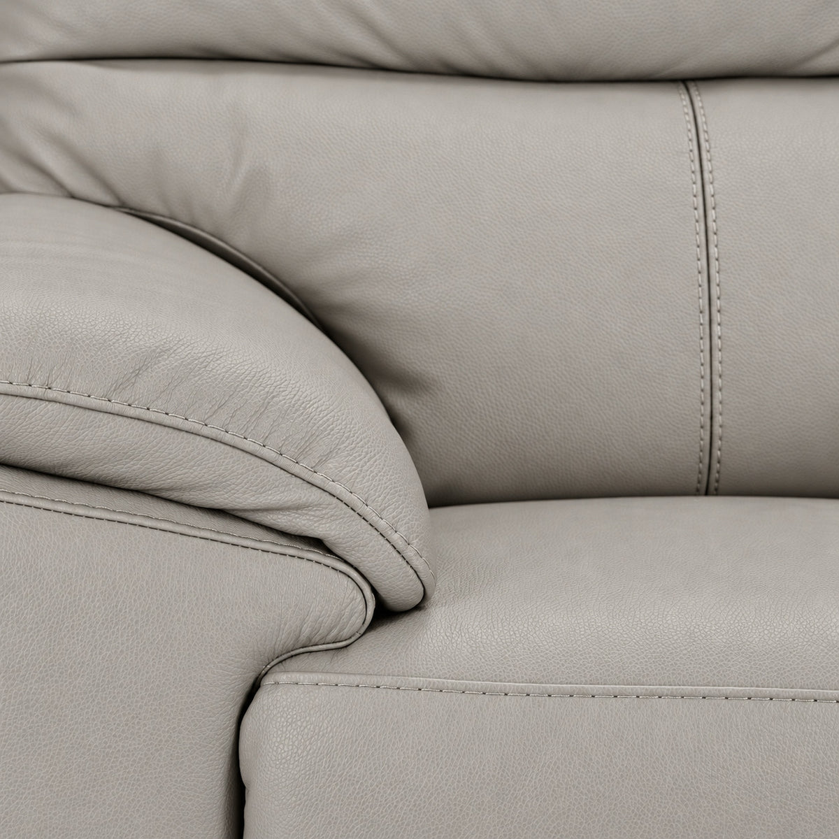 Close-up of grey leather texture, stitching, padded arm and seat cushion