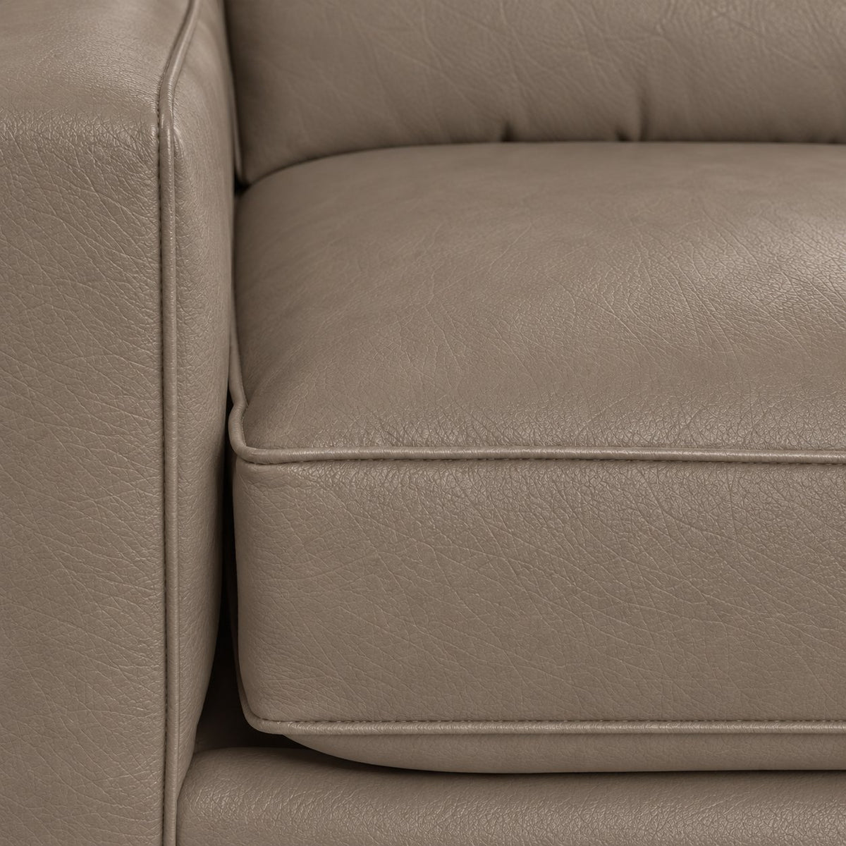 Close-up of the City Leather collection in Stone showing textured leather upholstery, piped cushion edges and stitching