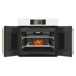 CAFÉ™ Professional Series 30" Matte White French-Door Wall Oven open with roasting trays on two racks