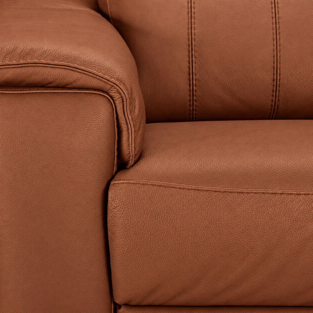 Close-up of cognac leather upholstery, padded arm, seat cushion and detailed stitching