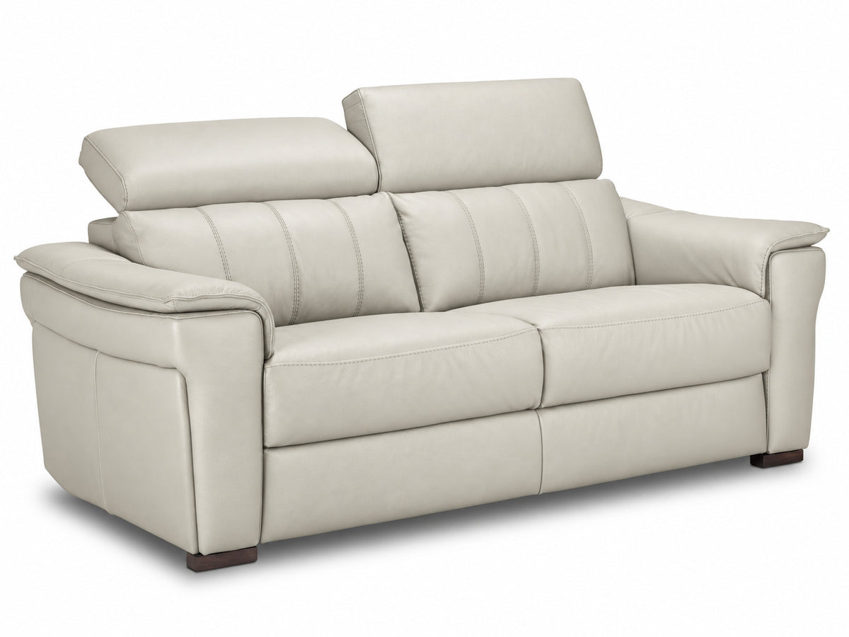 Angled sofa with one headrest lowered to demonstrate adjustable positioning