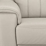 Close-up of cream leather upholstery showing grain, stitching, padded arm and seat cushion