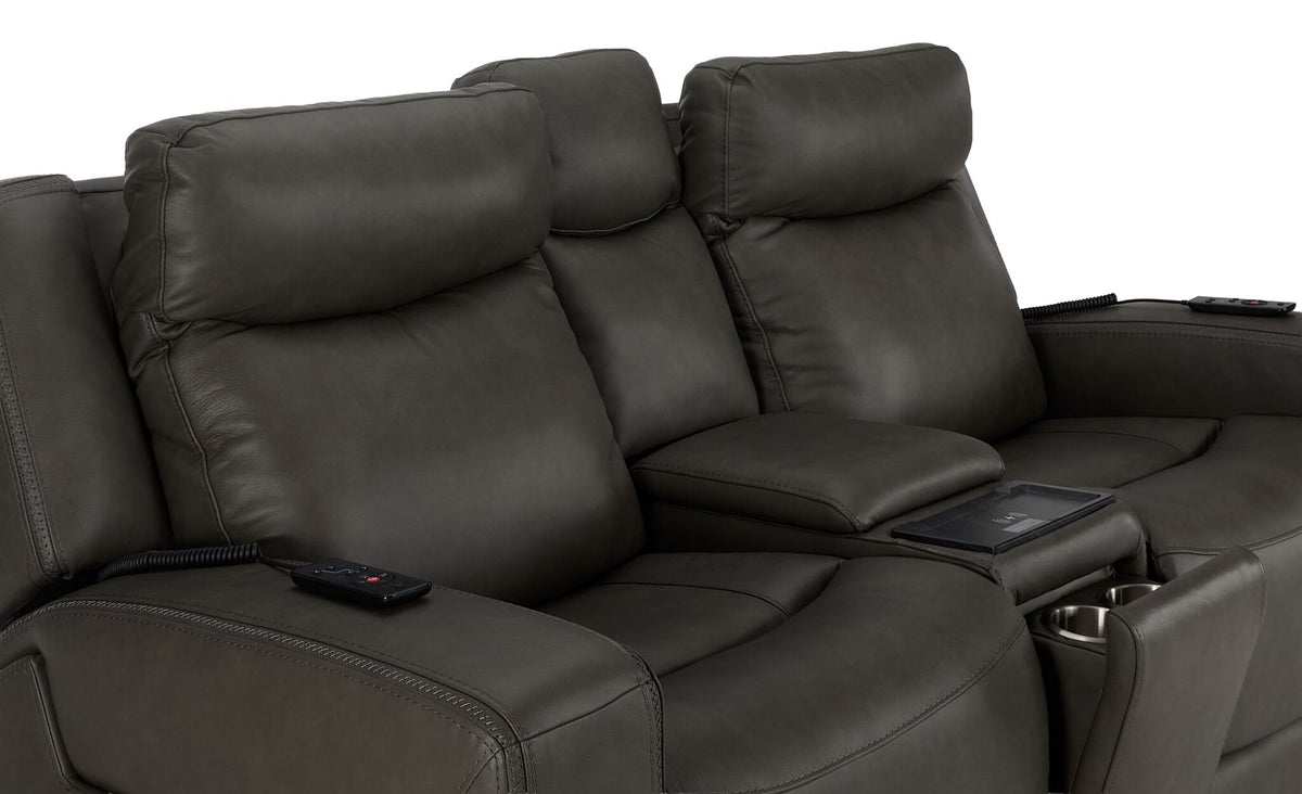 Jackson anthracite leather loveseat close-up showing padded headrests, stitched seats, centre console and remotes