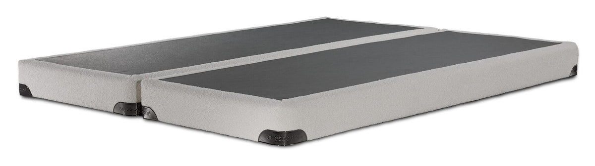 Angled view of the Kingsdown queen split low-profile boxspring with beige upholstery and black support surfaces