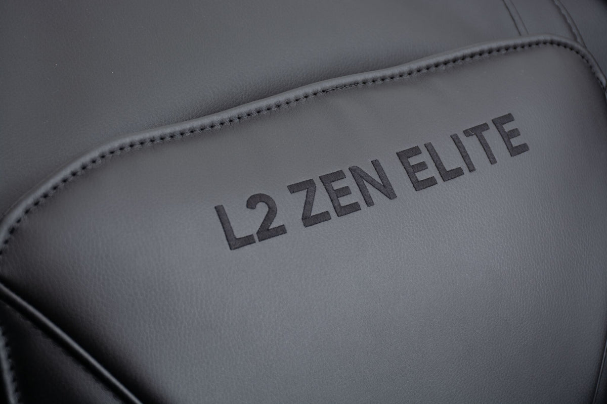 Close-up of the L2 Zen Elite branding embroidered on the black padded massage chair headrest