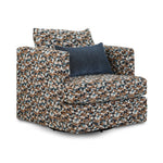 Laila swivel accent chair with multicolour patterned upholstery, rounded arms and a blue lumbar pillow