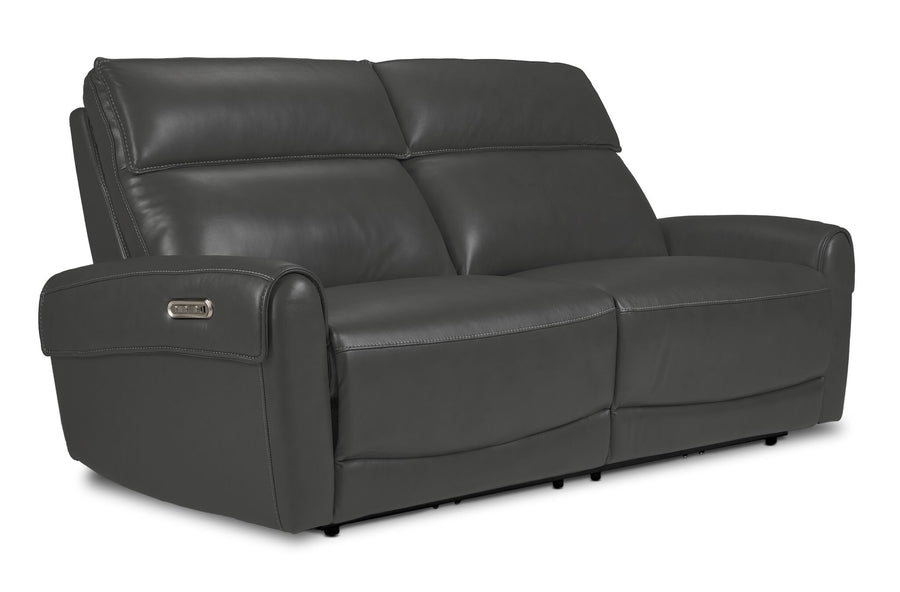 Theo Leather Dual Power Reclining Sofa - Granite shown at an angle with plush back cushions, padded armrests and contrast stitching