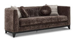 Tresor dark brown sofa with curved back, button-tufted detail, accent pillows and angled front view