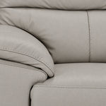 Close-up of grey leather grain, stitching, cushioned arm and seat